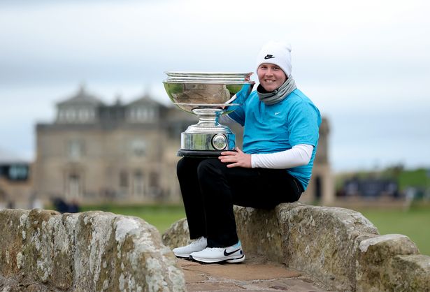 Bob MacIntyre poses with the Alfred Dunhill Links Championship trophy on the Swilcan Bridge at St. Andrews