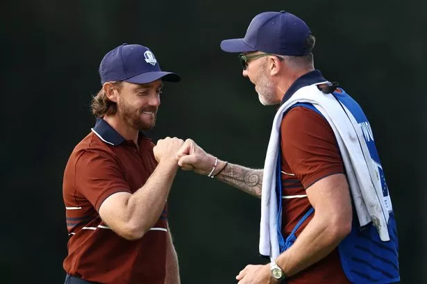 Tommy Fleetwood of Team Europe reacts with his caddie, Ian Finnis, on the second green during the Saturday morning foursomes matches of the 2025 Ryder Cup at Black Course at Bethpage State Park Golf Course on September 27, 2025 in Farmingdale, New York.