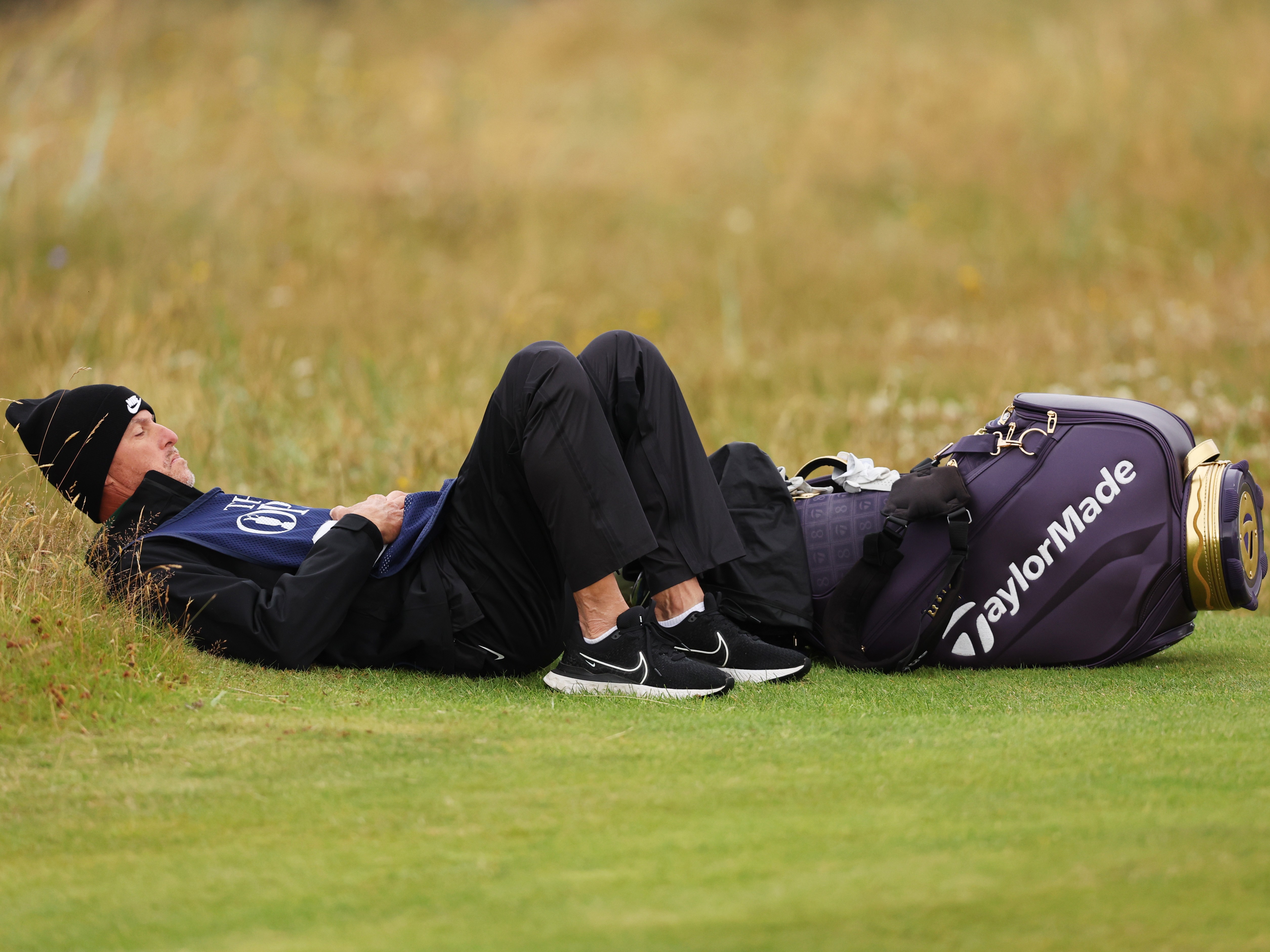 Ted Scott lying down beside his bag at The Open taking a breather