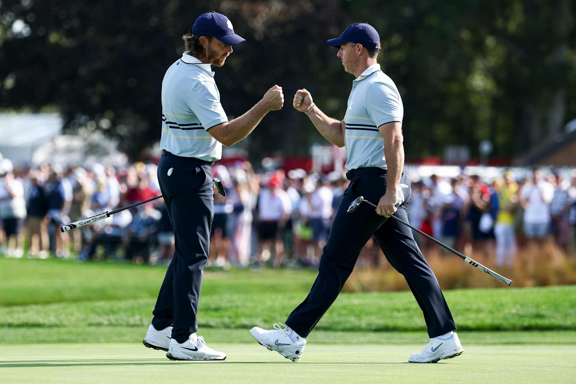 FARMINGDALE, NEW YORK - SEPTEMBER 26: Tommy Fleetwood fist bumps teammate Rory McIlroy of Team Europe on the 12th green during the Friday morning foursomes matches of the 2025 Ryder Cup at Black Course at Bethpage State Park Golf Course on September 26, 2025 in Farmingdale, New York. (Photo by Jared C. Tilton/Getty Images)