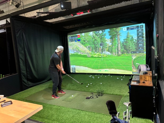 Corbin Taylor putts on a virtual green at BetterGolf. (Caroline Hemphill - Santa Cruz Sentinel)