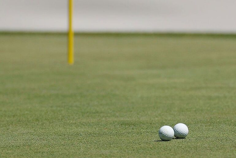 My Golf Ball Just Knocked Another Golf Ball Into The Hole. Two golf balls collide