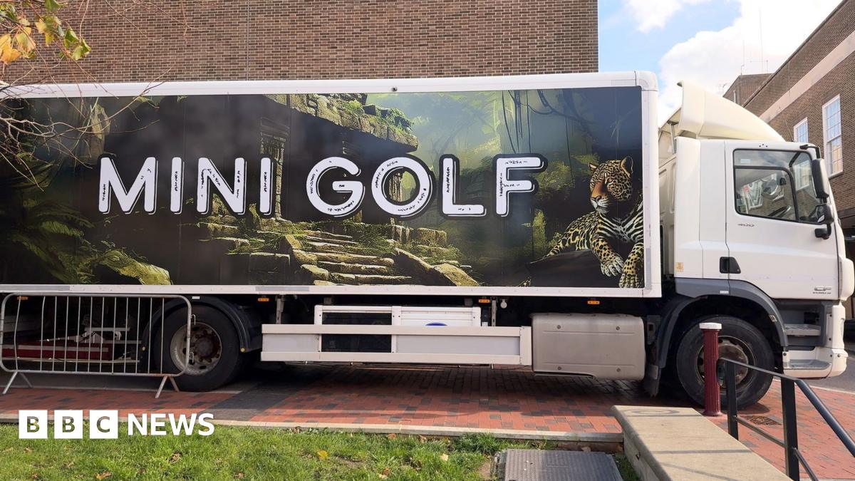 Professional Idiots build mini golf course in lorry in Kent A lorry with mini golf on the side parked outside the townhall