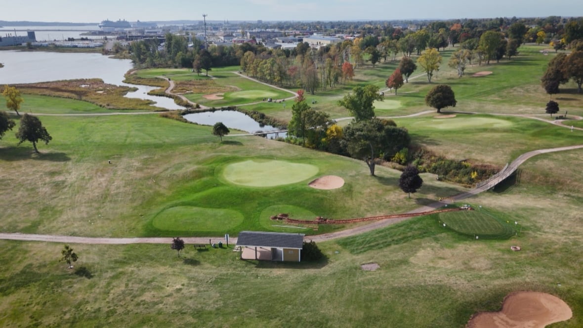A drone shot of the Belvedere Golf Club. There are lots of open fields with lakes and trees in the distance.