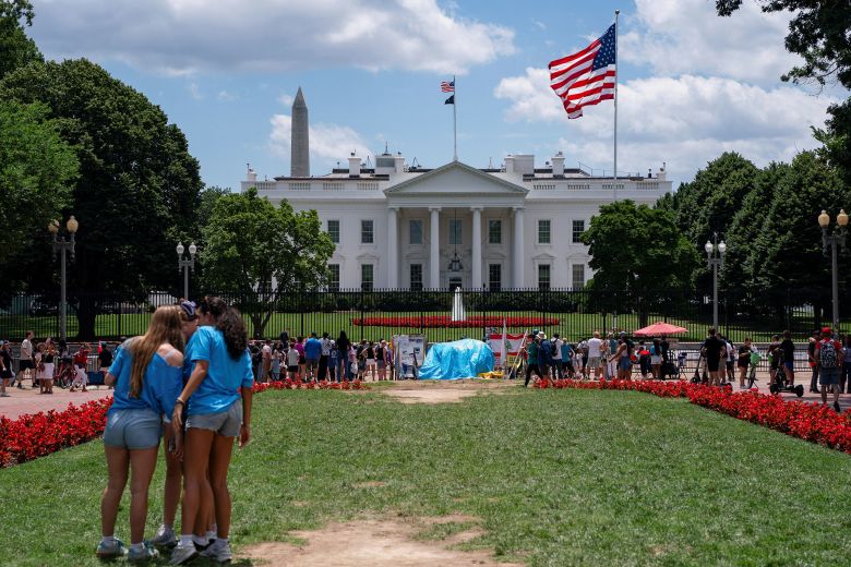 Visitors walk past the White House as a new flag pole installed on the North Lawn stands, on June 19.