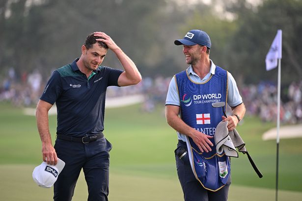 Laurie Canter of England reacts on the 18th green alongside his caddie on day four of the DP World Tour Championship