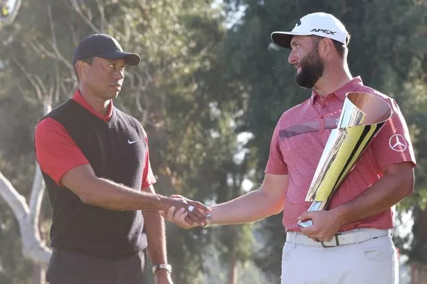 Jon Rahm shakes hands with Tiger Woods