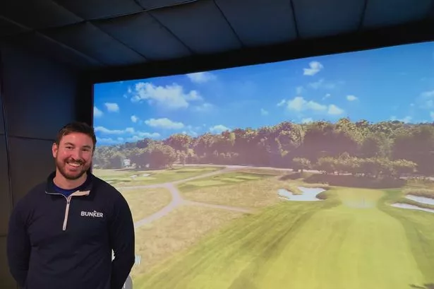 Bunker Indoor Golf co-founder Adam Grace next to a high-tech indoor golf booth at the Sneinton venue.