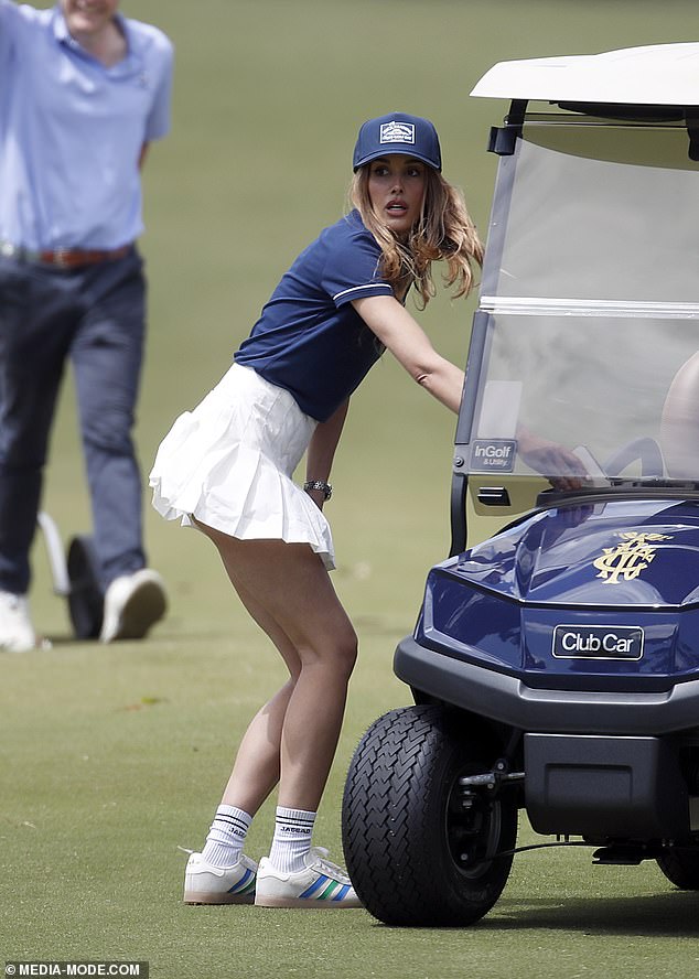 She topped the frock with a navy blue polo shirt to match her cap