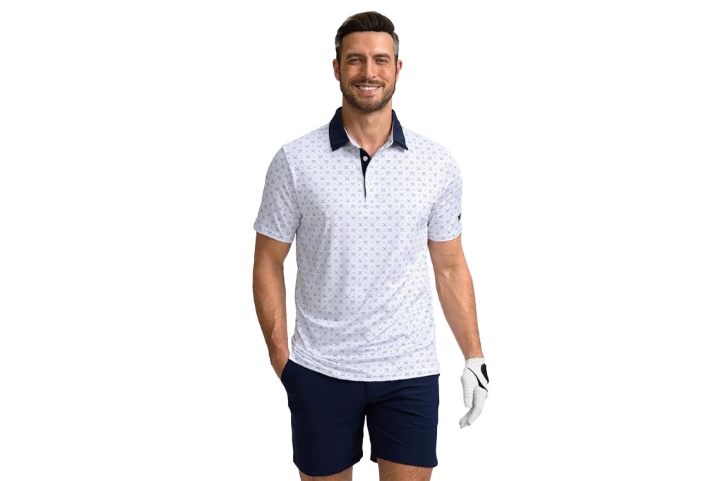 A man wearing a white polo shirt with a repeating golf club pattern, navy blue shorts, and a golf glove on his left hand.