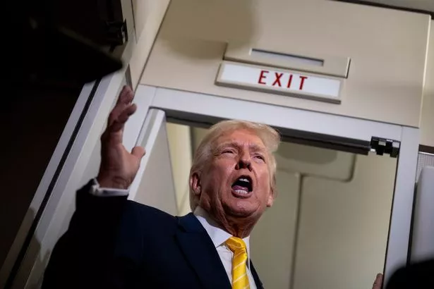 U.S. President Donald Trump speaks to members of press aboard Air Force One on November 14, 2025 while in flight from Washington, DC to West Palm Beach International Airport. 
