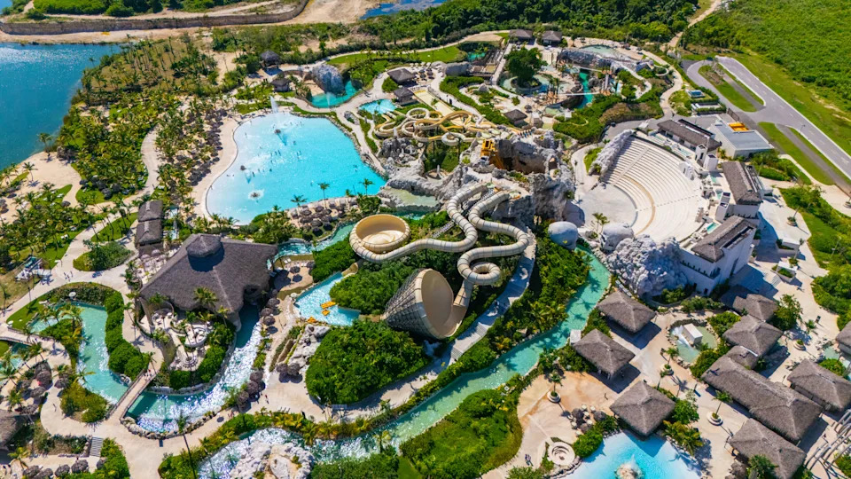 Aerial view of Scape Park in Cap Cana, Dominican Republic, showing turquoise pools, water slides, and lush tropical landscaping.