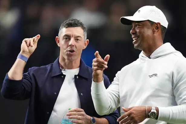 Rory McIlroy and Tiger Woods stand on the green as they watch New York Golf Club and The Bay Golf Club warmup for the inaugural match of the TMRW Golf League