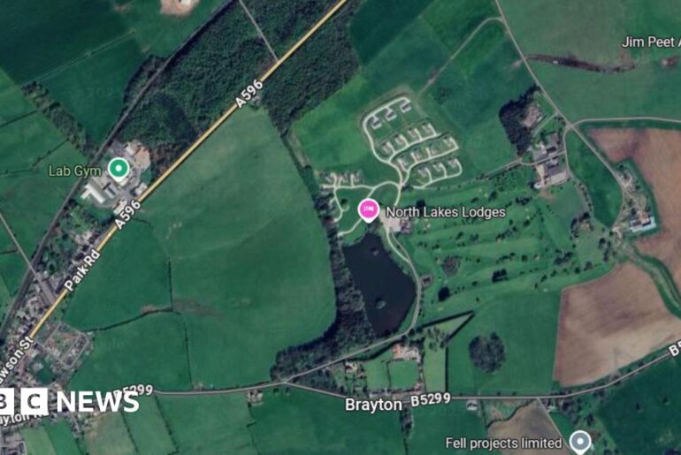 A Google Maps screenshot showing an aerial view of the location where North Lakes Lodges is. It is on a parcel of land between the A596 and the B5299. The area is mostly surrounded by green space.