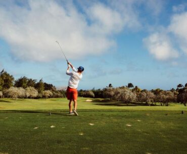 Panoramic view of brg kings island golf resort in hanoi, showcasing lush green fairways and water features under a clear sky, symbolizing the city