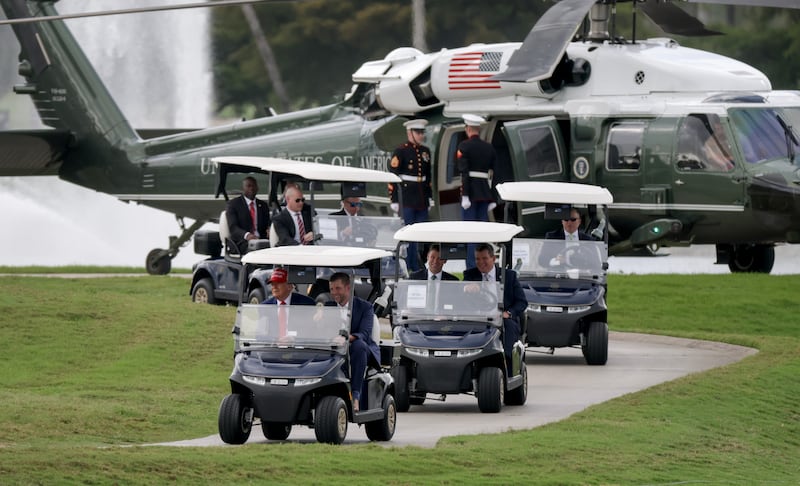 DORAL, FLORIDA - APRIL 03: U.S. President Donald Trump and his son, Eric Trump, drive in a golf cart after he arrived on Marine One at the LIV Golf tournament being held at his Trump National Doral Golf Club on April 03, 2025 in Doral, Florida.