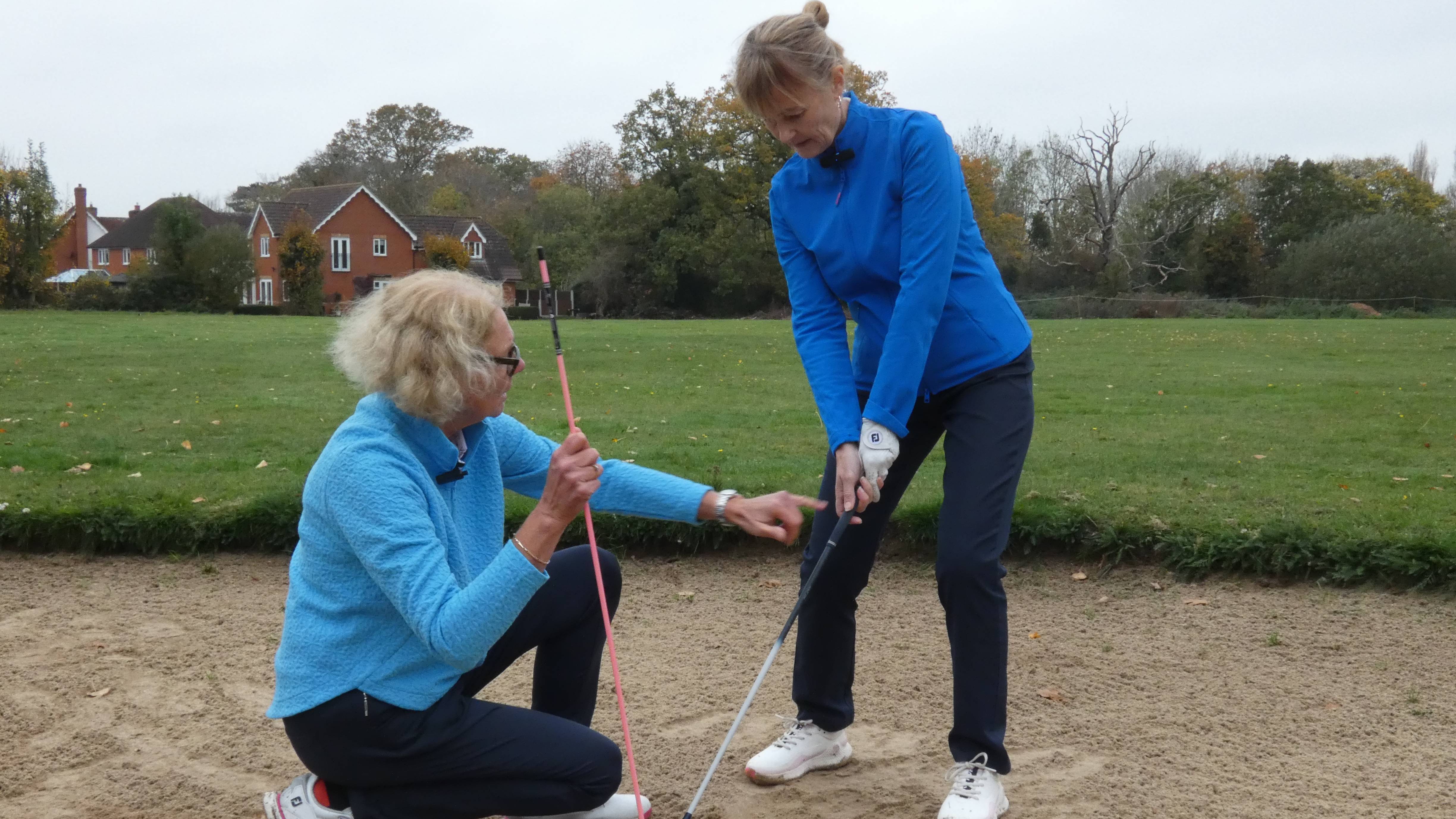 Sarah Bennett changing Alison Root's grip in a bunker