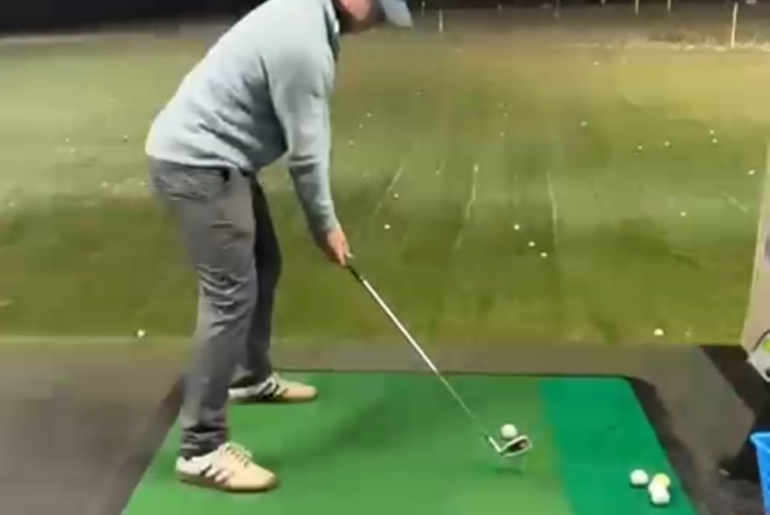 How do I stop standing up at the top of my back swing?