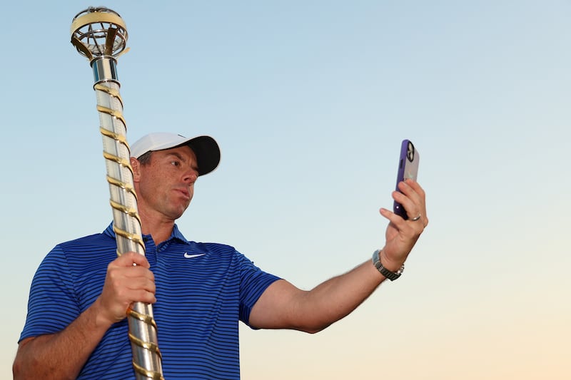 Rory McIlroy of Northern Ireland poses for a selfie with the DP World Tour Championship trophy on the 18th green following victory at the DP World Tour Championship 2024. Photograph: Luke Walker/Getty