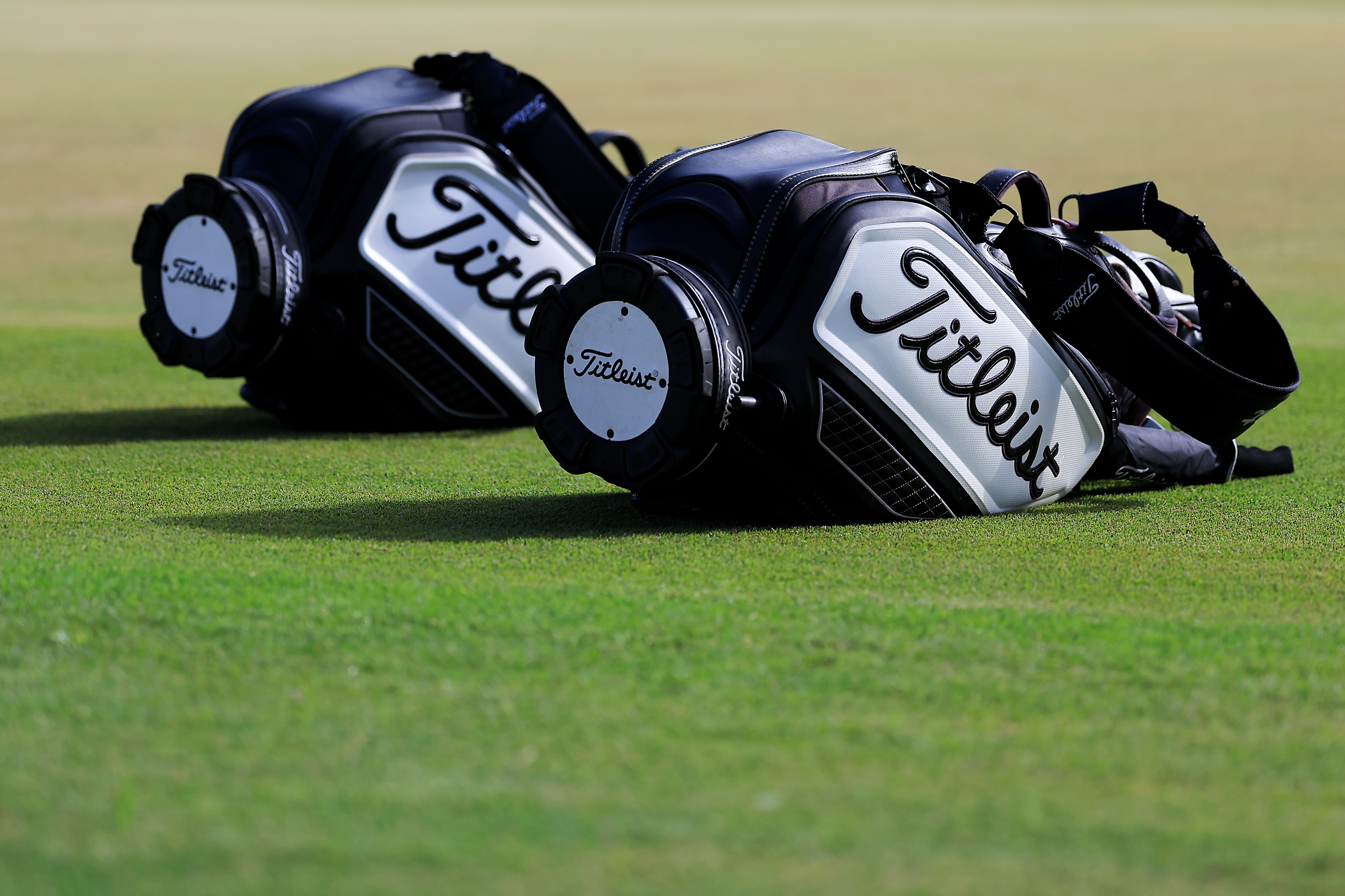 Two Titleist bags on the ground