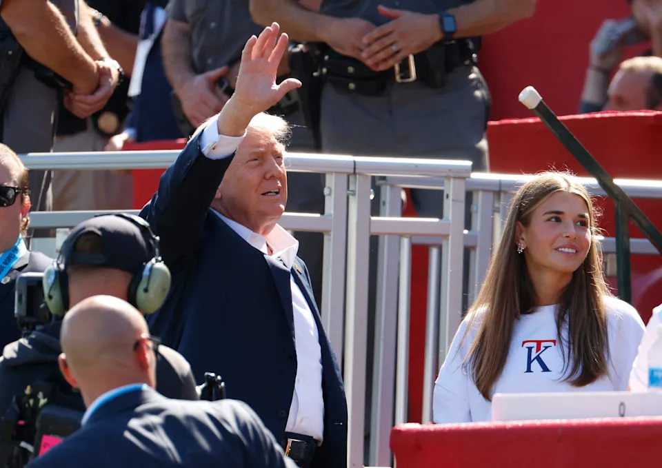 Golf - The 2025 Ryder Cup - Bethpage Black Golf Course, Farmingdale, New York, United States - September 26, 2025 U.S. President Donald Trump waves to the crowd on the 1st tee before the start of the four-balls as his granddaughter Kai Madison Trump look on IMAGN IMAGES via Reuters/Peter Casey