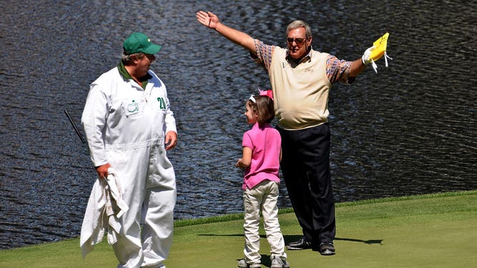 Fuzzy Zoeller celebrates with a young patron on the ninth green during the Par 3 Contest prior to the 2009 Masters Tournament at Augusta National Golf Club. 