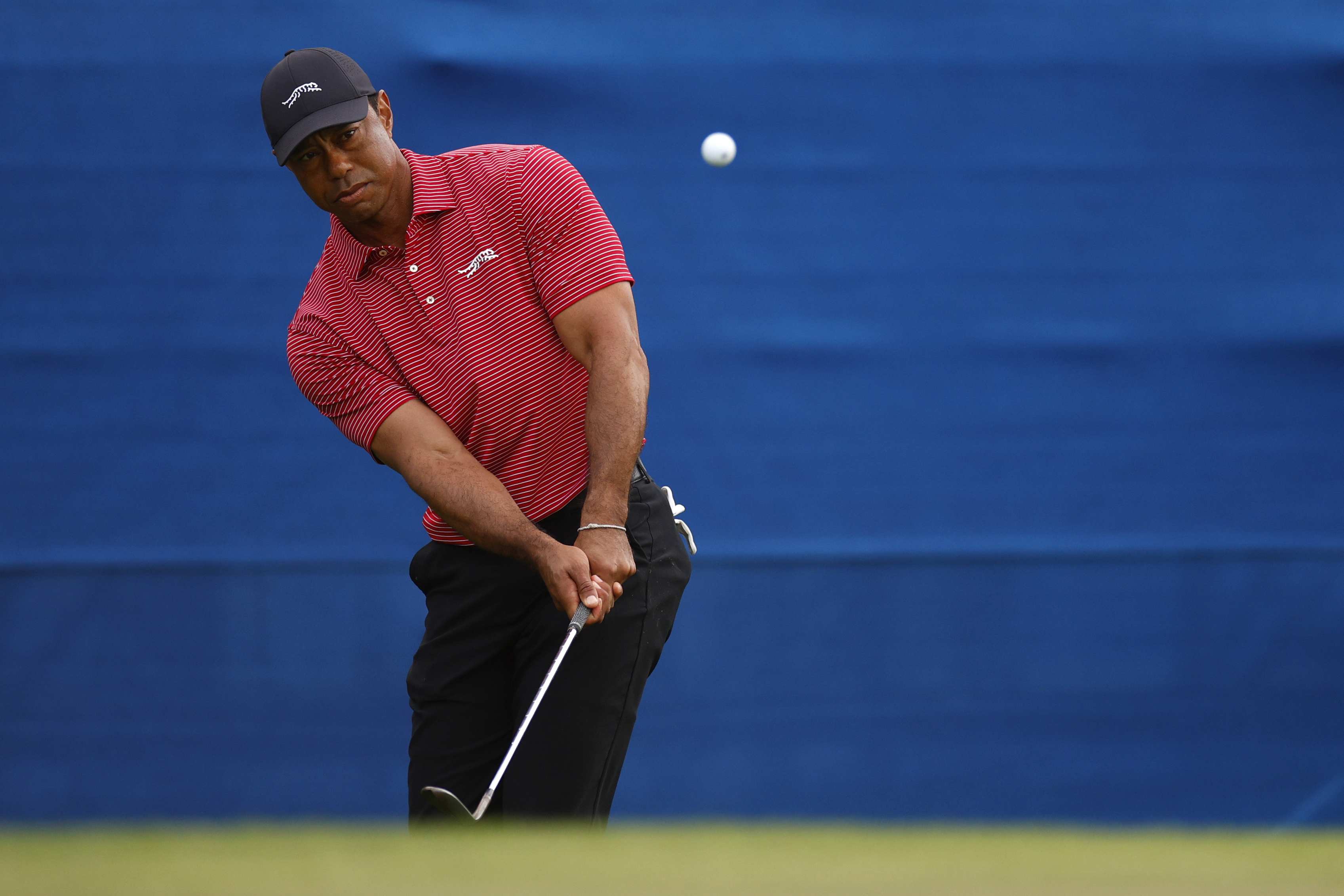 Tiger Woods hits a wedge shot around the green