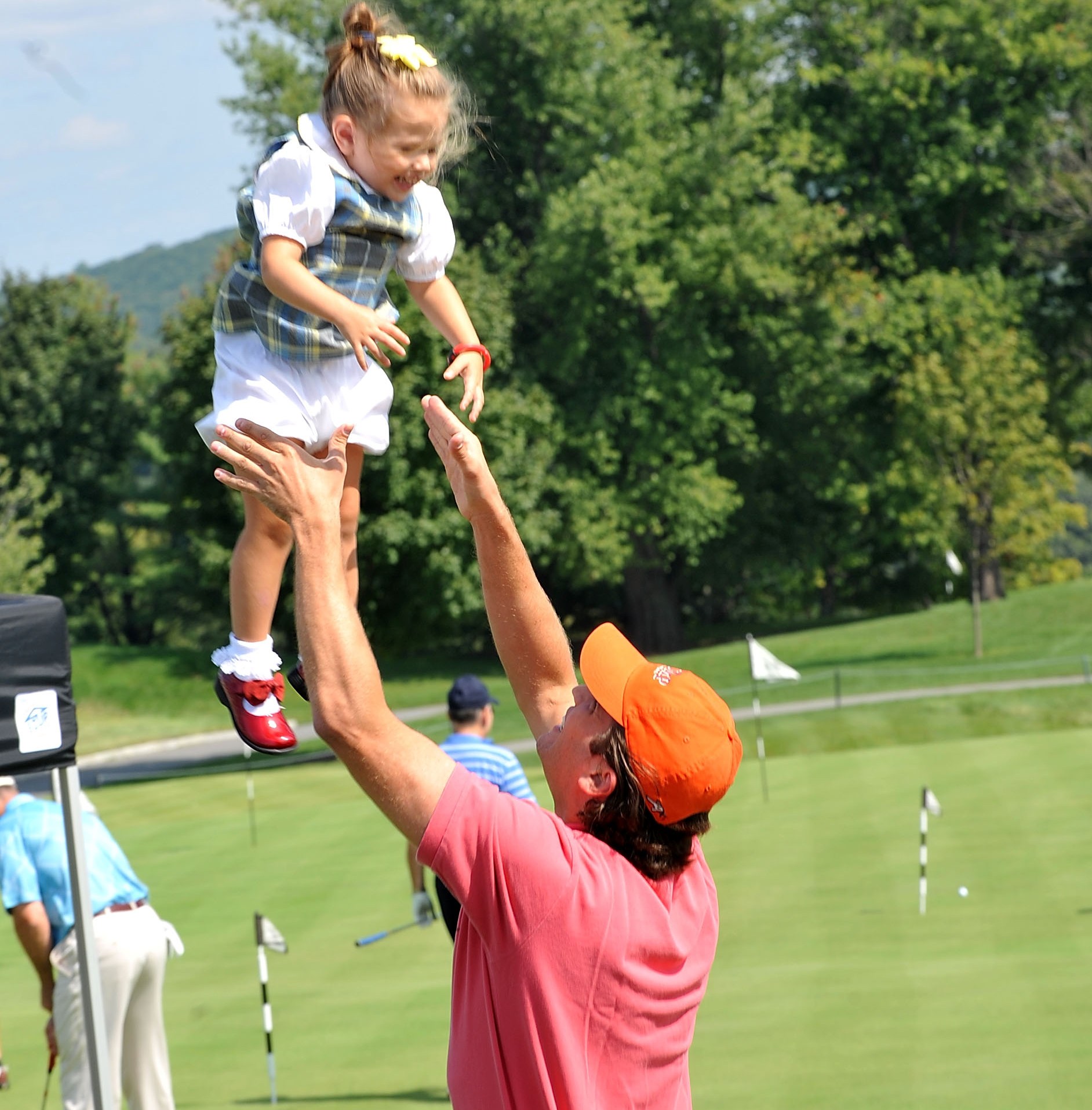 Donald Trump Jr. lifting his daughter Kai Madison Trump in the air at the 3rd annual Eric Trump Foundation Golf Invitational.