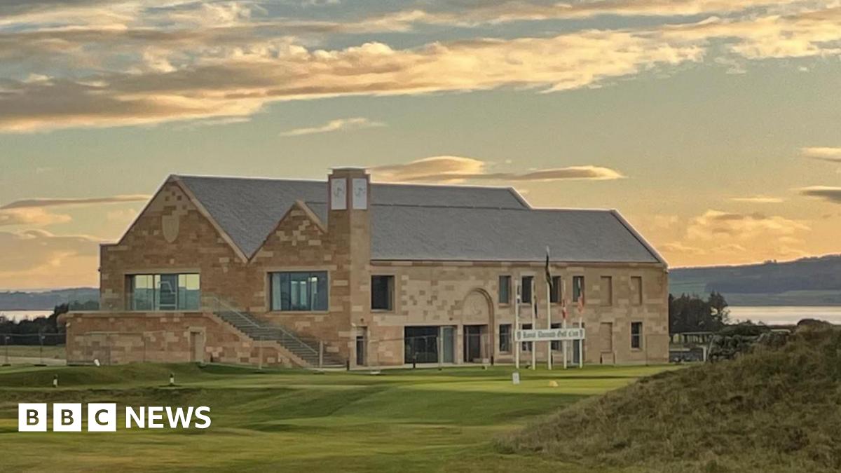 New £13.9m clubhouse opens at Royal Dornoch The sun has just gone down and clouds are lit in orange and gold colours above the new clubhouse at Royal Dornoch. It is a large building made of sandstone with a slate roof. A golf tee point is located in front of the building.