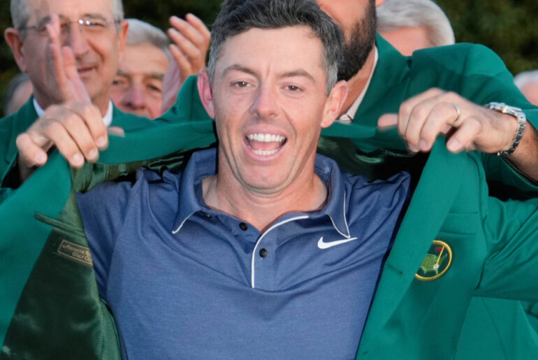 Rory McIlroy putting on green jacket after winning The Masters