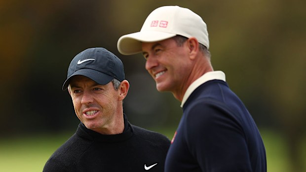 Rory McIlroy (L) speaks with Adam Scott (R) during practice prior to the Crown Australian Open 2025.