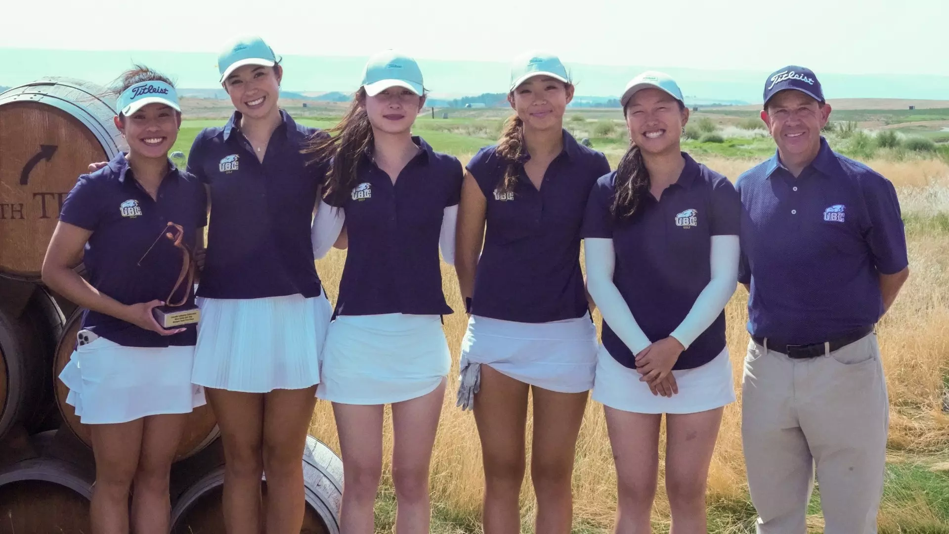 UBC Thunderbirds women's golf smiling and posing with their trophy, along with assistant coach Jeff Buder, after winning the 2025 Wine Valley Invitational, hosted by Walla Walla University