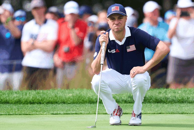 Justin Thomas crouches down behind a putt during day two of the 2025 Ryder Cup at Bethpage Black