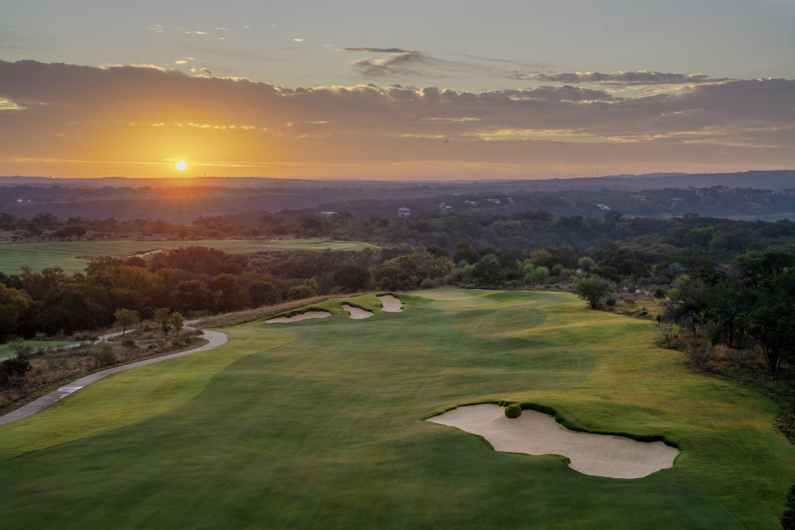 An aerial view of a golf course at sunset.