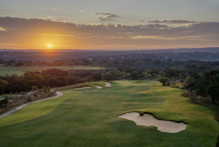An aerial view of a golf course at sunset.