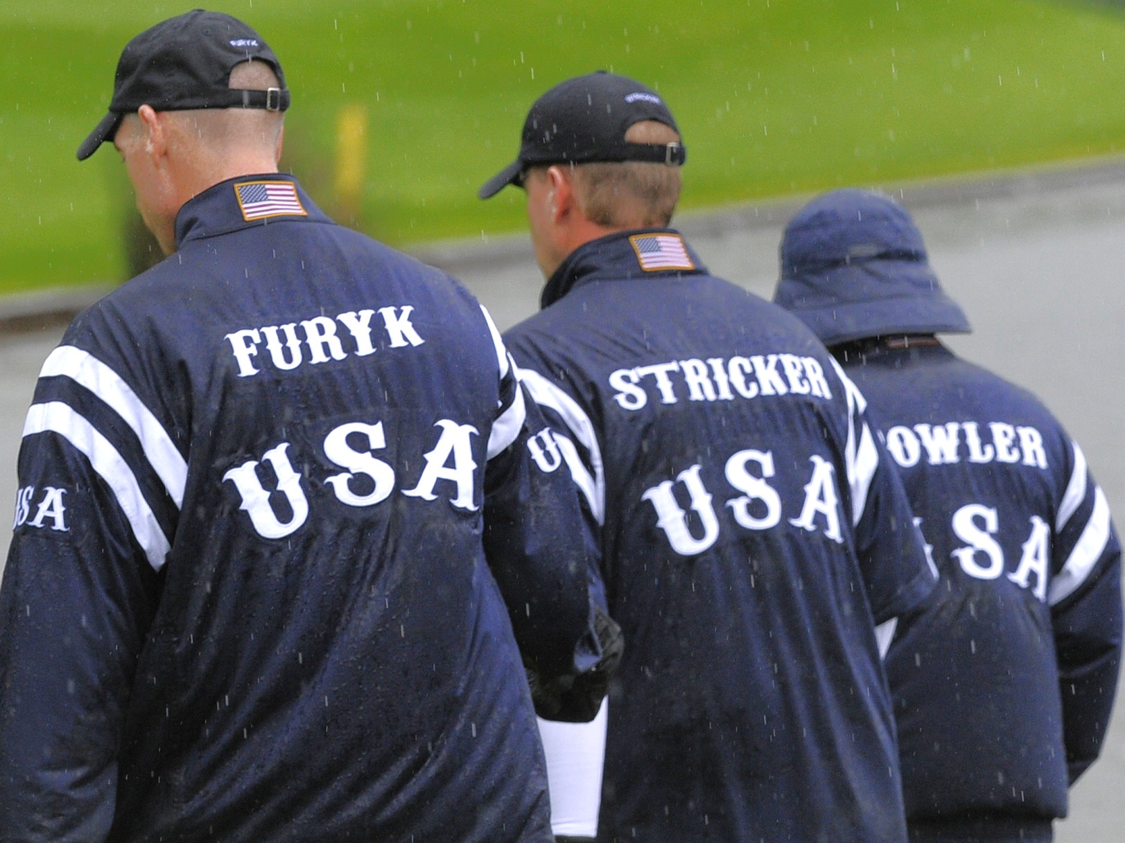 Back view of three of the USA Ryder Cup team in their waterproof jackets with their names on the back - Furyk, Stricker and Fowler.
