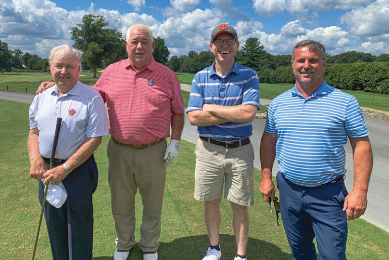Group of men standing outdoors on a golf course