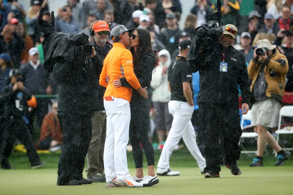 Rickie Fowler is met and congratulated by his now-wife Allison Stokke on the 18th green after winning the Waste Management Phoenix Open at TPC Scottsdale on February 03, 2019 in Scottsdale, Arizona.