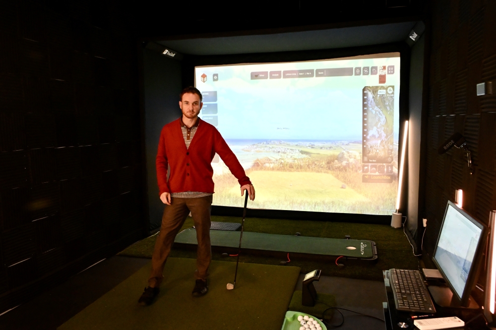 Owner Myles Vlachos stands in the simulator studio of Golf University.