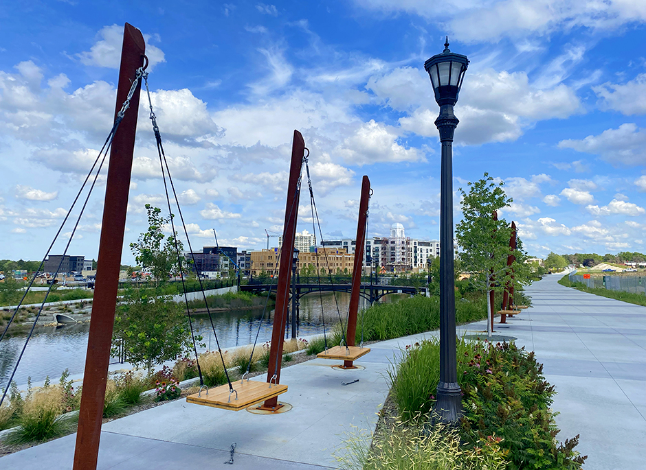 a walkway with a bridge and buildings in the background