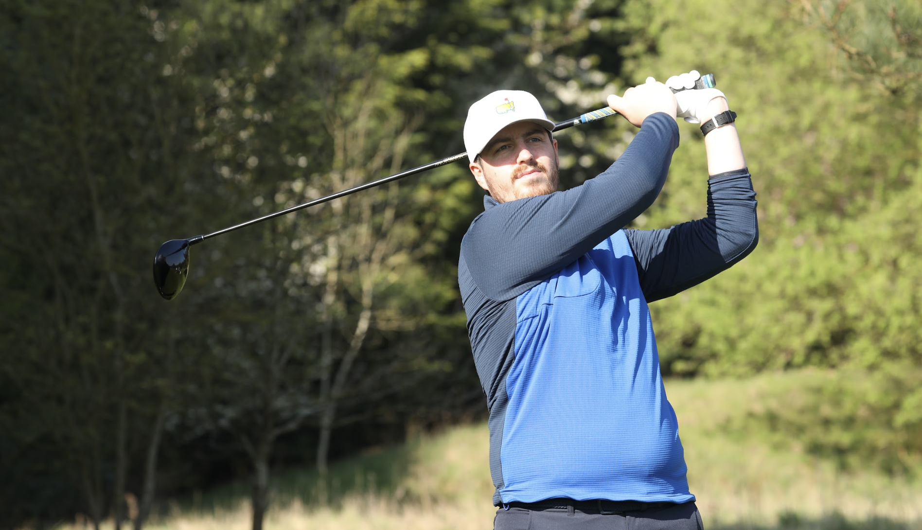 Golfer holds their finish after hitting a drive