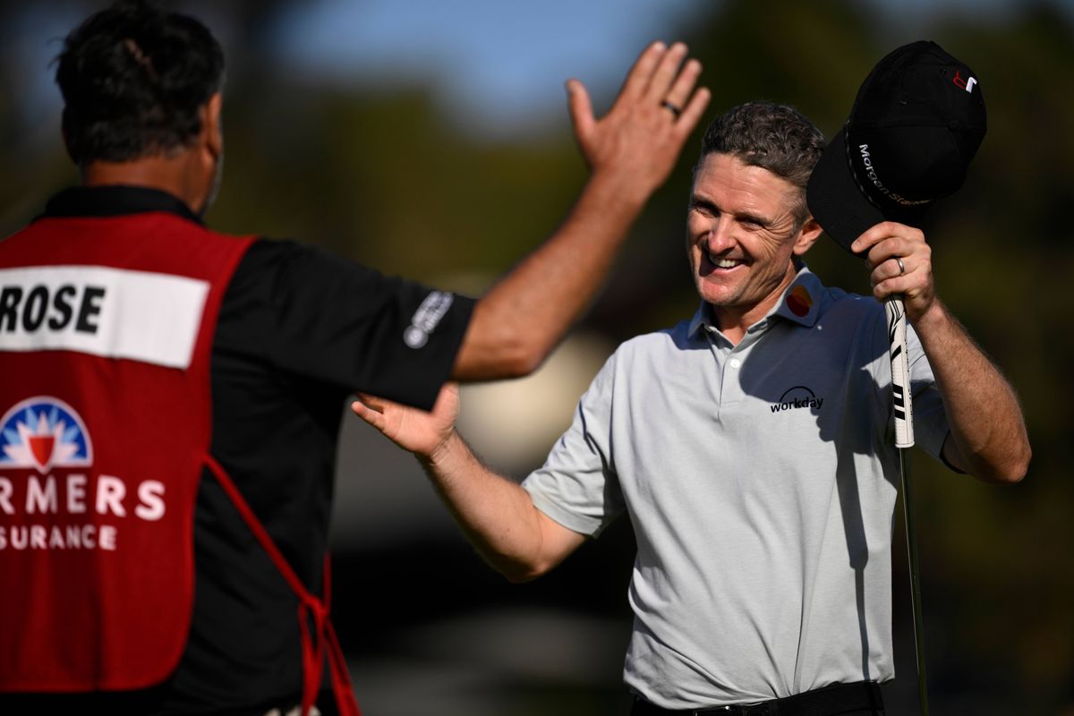 Justin Rose celebrates his seven-shot win at the Farmers Insurance Open with his caddie Mark Fulcher
