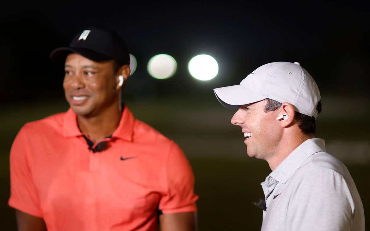 Tiger Woods of the United States and Rory McIlroy of Northern Ireland talk to sportscaster Kathryn Tappen during The Match 7 at Pelican Golf Club on December 10, 2022 in Belleair, Florida. 