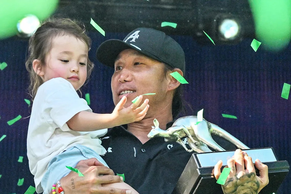 4Aces GC player Anthony Kim from the US celebrates on the podium with his daughter Isabella after he won the LIV Golf Adelaide tournament at The Grange Golf Club in Adelaide on February 15, 2026.