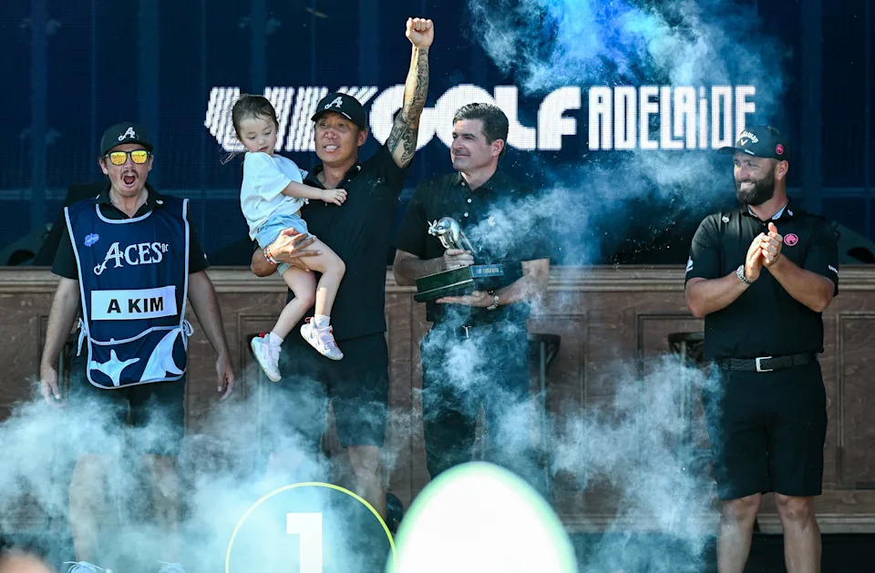 Anthony Kim of the Aces holds his daughter Bella and celebrates winning the tournament during the podium presentations of the day four of LIV Adelaide at The Grange Golf Club on February 15, 2026 in Adelaide, Australia.