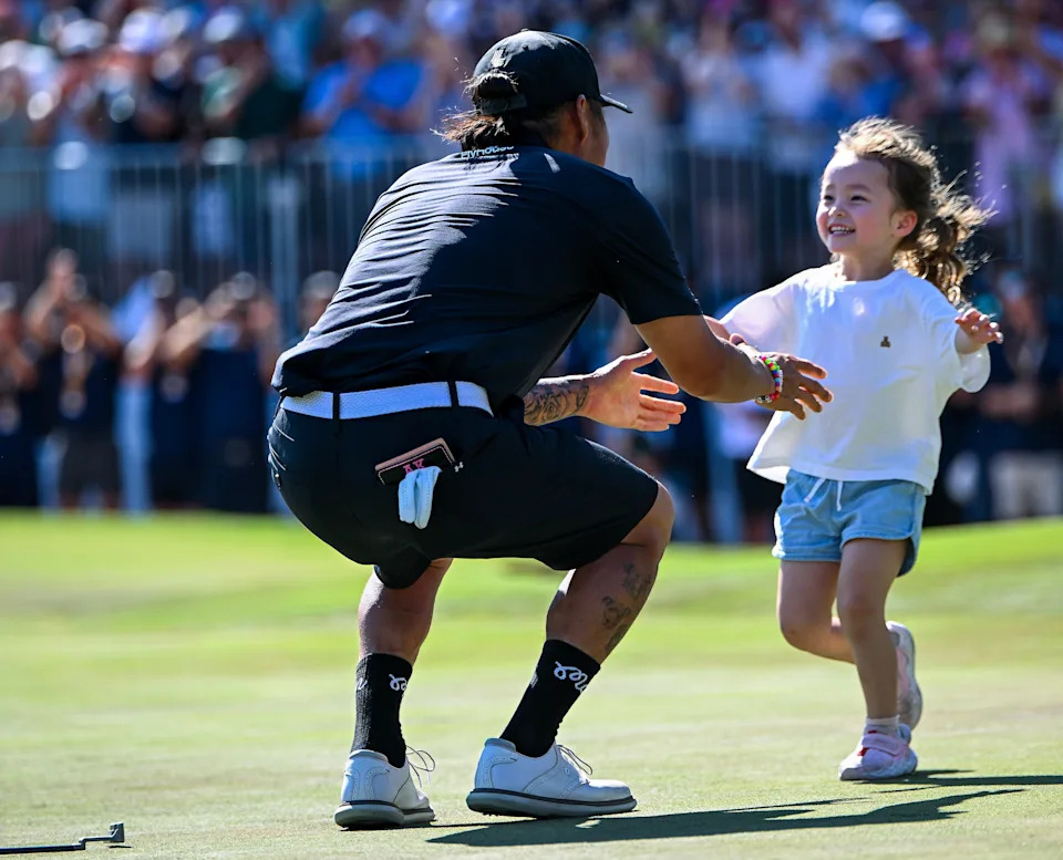 Anthony Kim of the Aces hugs his daughter Bella after winning the tournament during day four of LIV Adelaide at The Grange Golf Club on February 15, 2026 in Adelaide, Australia.