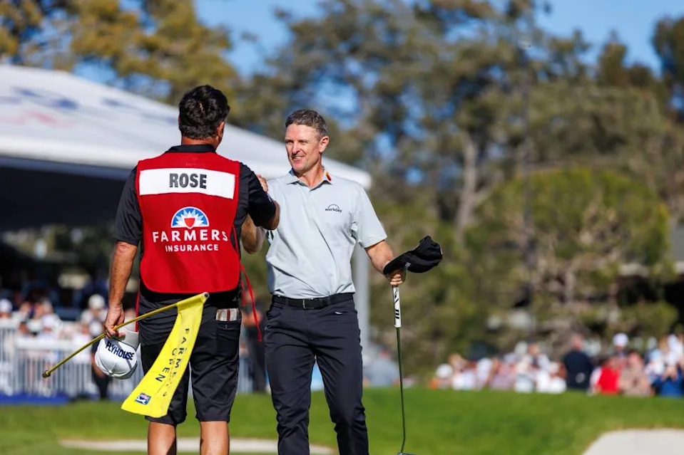 Justin Rose celebrates with his caddie after winning the Farmers Insurance Open on Feb. 1. Imagn Images
