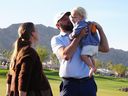 After winning the American Express golf event, Scottie Scheffler, centre, celebrates with son Bennett, right, and wife Meredith Scudder-Scheffler, left, on the Pete Dye Stadium Course at PGA West Sunday, Jan. 25, 2026, in La Quinta, Calif.