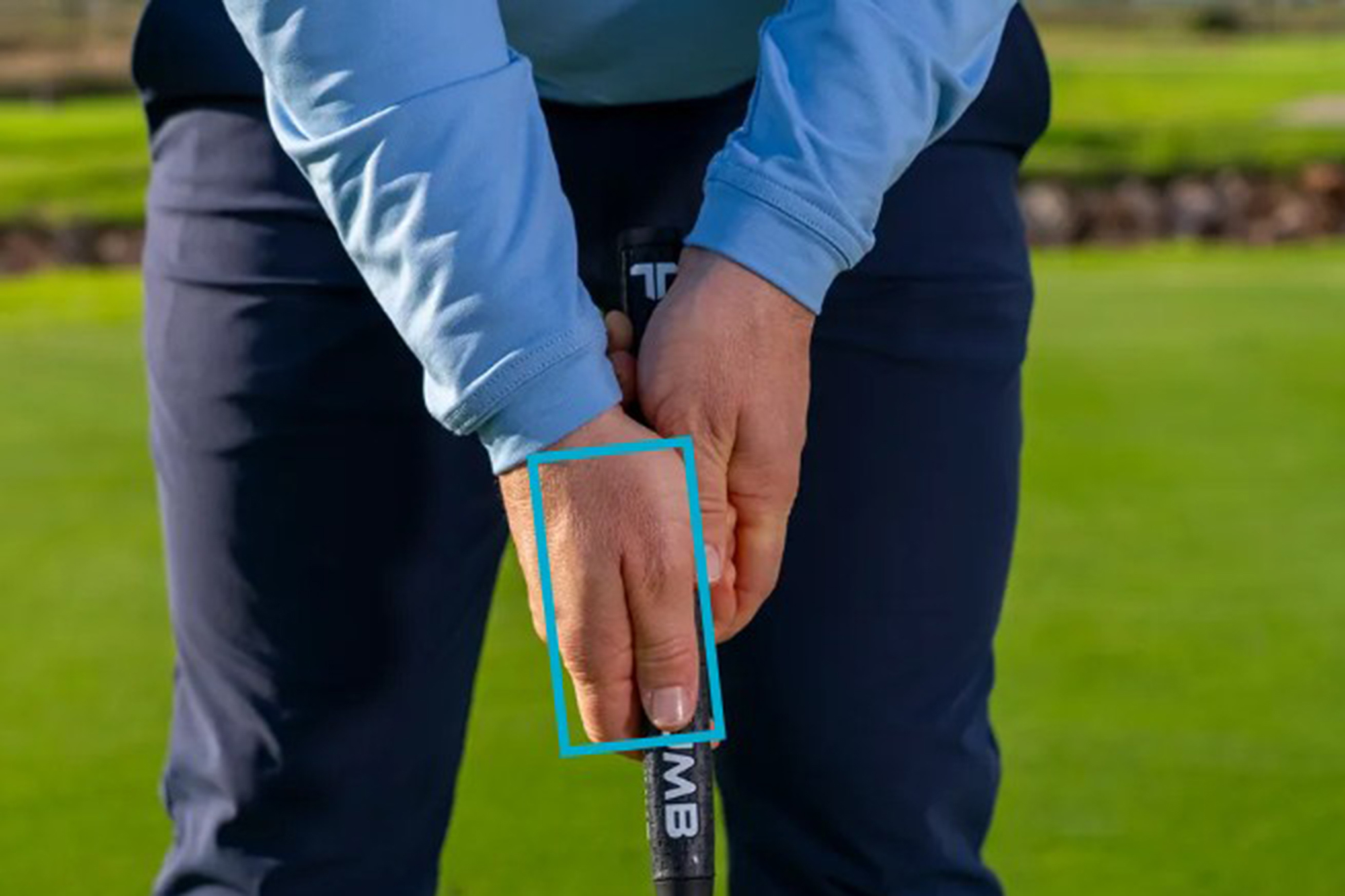 James Jankowski demonstrating the correct position of the right hand on the club for a conventional putting grip, with the blue rectangle focusing on the position of the right thumb on the grip