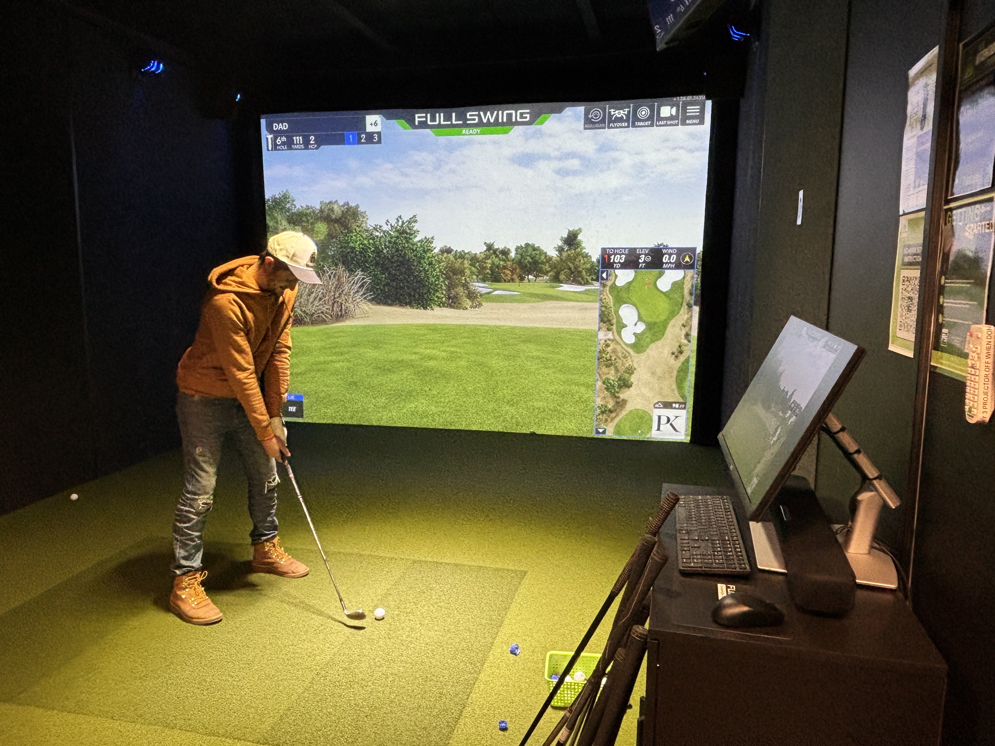 John Evans plays golf in a simulator bay at the...